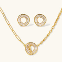 Gold-plated necklace and earring set with circular CZ crystal pendants featuring radial design on cream background