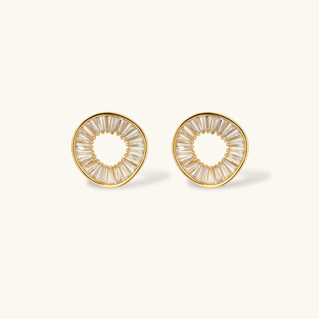 Gold-plated necklace and earring set with circular CZ crystal pendants featuring radial design on cream background