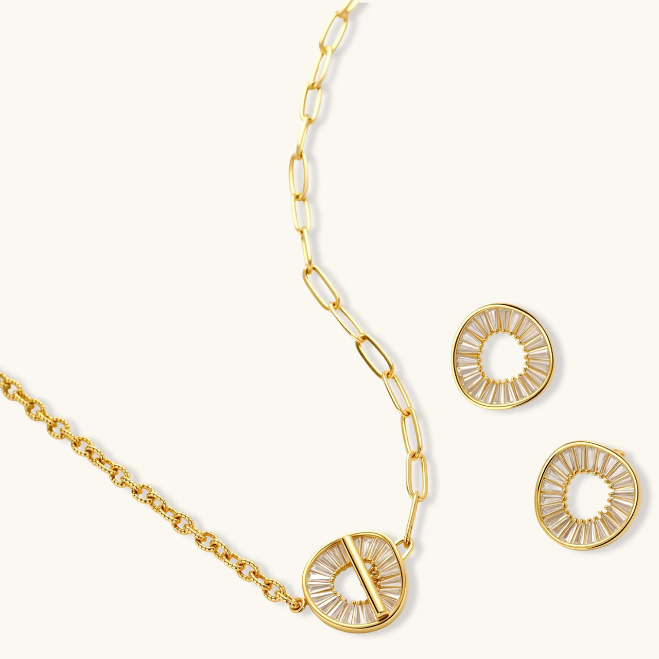 Gold-plated necklace and earring set with circular CZ crystal pendants featuring radial design on cream background