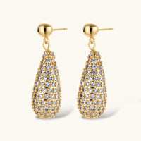 Gold-plated teardrop necklace and earrings covered in AAA cubic zirconia crystals on cream background.