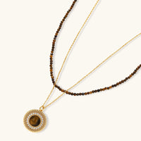 Gold-plated circular pendant necklace and matching earrings with natural stone centers and ornate rope detailing