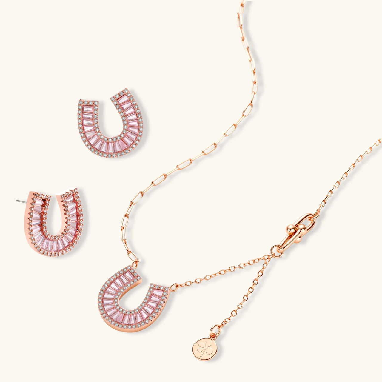 Sparkling horseshoe-shaped jewelry set with AAA cubic zirconia in gold-plated and white gold finishes on cream background.