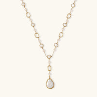 Long gold-plated necklace with alternating freshwater pearls and crystal bezels, featuring a large baroque pearl pendant