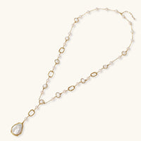 Long gold-plated necklace with alternating freshwater pearls and crystal bezels, featuring a large baroque pearl pendant