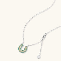 Geometric horseshoe-shaped jewelry set with radiating white zirconia center and jade-green border stones on white background.