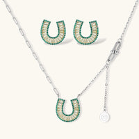 Geometric horseshoe-shaped jewelry set with radiating white zirconia center and jade-green border stones on white background.