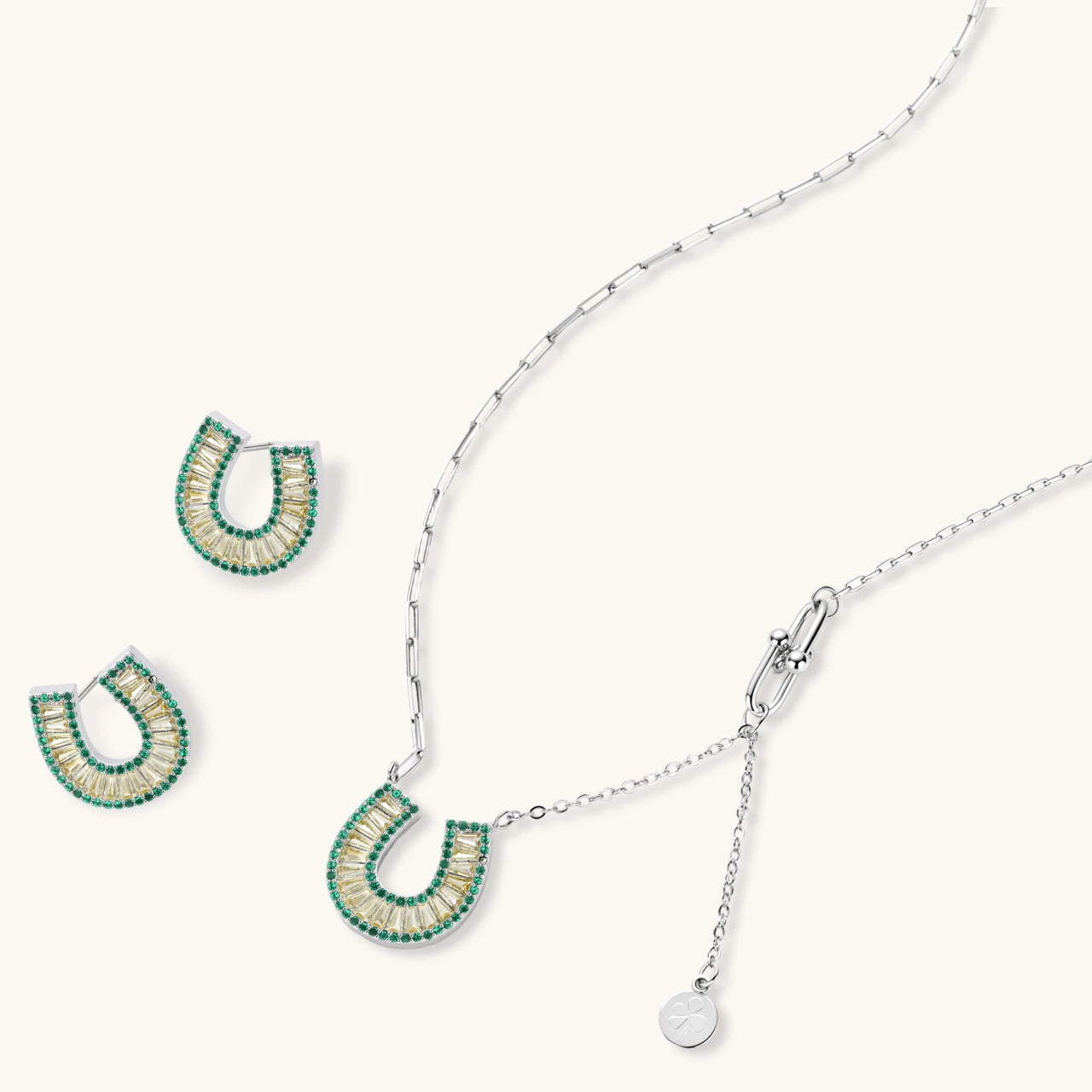 Geometric horseshoe-shaped jewelry set with radiating white zirconia center and jade-green border stones on white background.