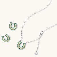 Geometric horseshoe-shaped jewelry set with radiating white zirconia center and jade-green border stones on white background.