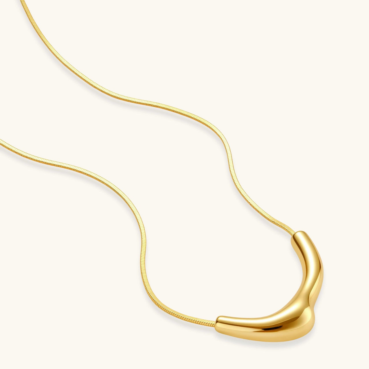 Curve Statement Necklace featuring a sleek gold-plated curved pendant on an adjustable chain.