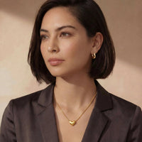 Golden Heart Necklace worn by a model, featuring a dainty heart pendant and adjustable chain.