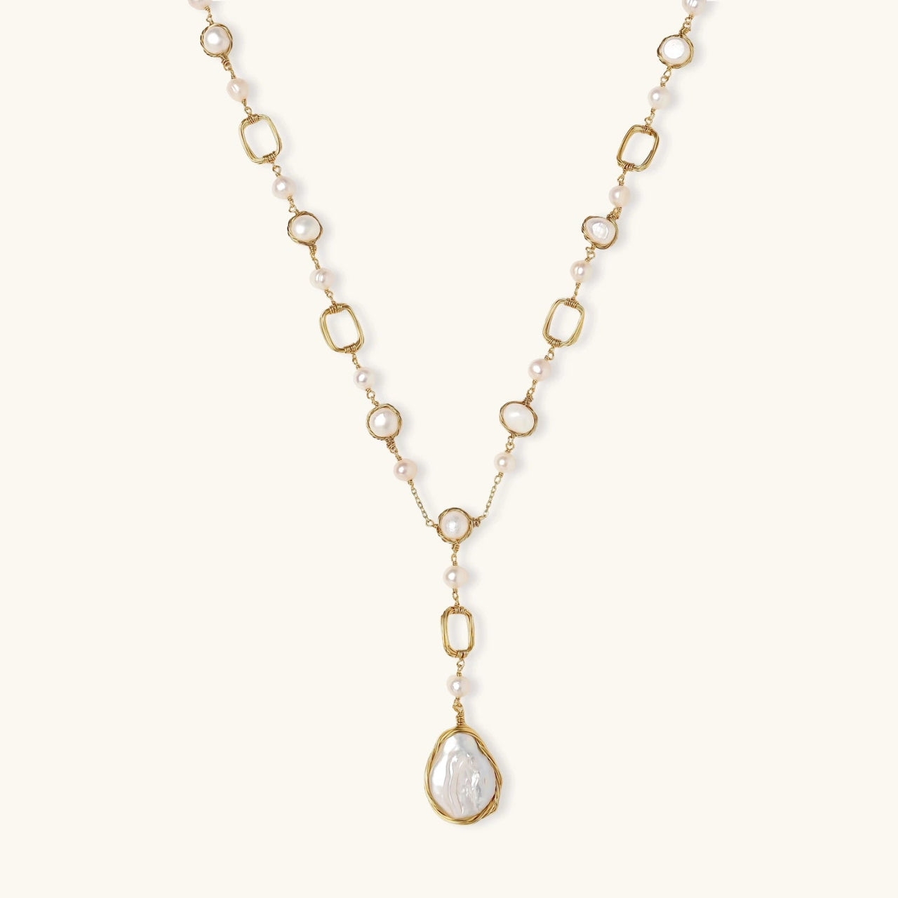 Lumina Pearl Station Necklace featuring freshwater pearls and a baroque pearl pendant on a gold-plated chain.