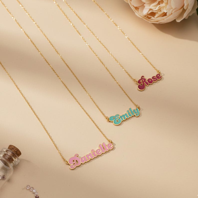 Personalized Cursive Name Necklace in gold featuring custom names Danielle, Emily, and Rose on a neutral background.