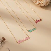 Personalized Cursive Name Necklace in gold featuring custom names Danielle, Emily, and Rose on a neutral background.