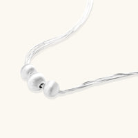 Close-up of the Silver Strand Layers Necklace showcasing brushed sterling silver beads and multi-strand chains.