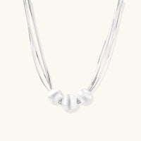 Silver Strand Layers Necklace featuring three brushed sterling silver beads and delicate multi-strand chains.